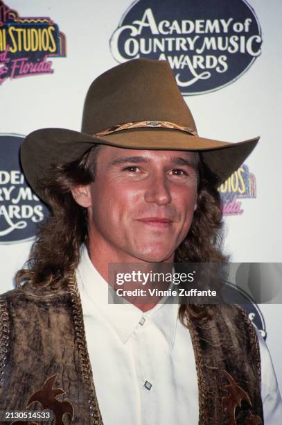 American singer, songwriter and musician Billy Dean, wearing a brown leather waistcoat over a white shirt with a brown fedora, in the 29th Annual...