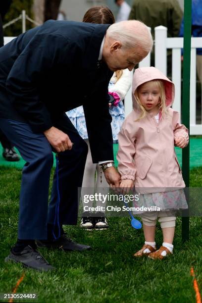 President Joe Biden helps a young guest roll her hard-boiled egg down the South Lawn during the White House Easter Egg Roll on April 01, 2024 in...
