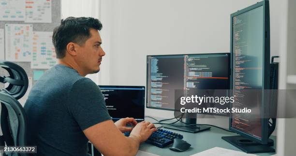 los desarrolladores de software jóvenes que usan la computadora para escribir un programa de aplicación de código para el desarrollo de tecnología de ia sentados en un escritorio con múltiples pantallas trabajan en la oficina en casa. desarrollo de pr - profesional de informática fotografías e imágenes de stock