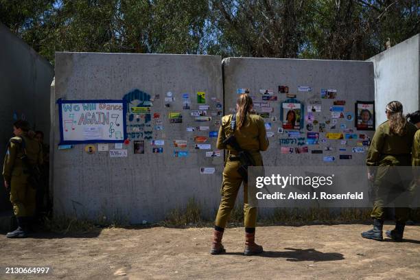 Female combat soldier from the "Ariyot Hayarden" unit stands outside a makeshift bomb shelter where the words "we will dance again" are seen on a...