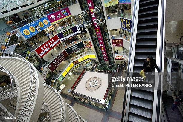 Lone shopper takes an escalator in an empty mall in Guangdong's second city of Shenzhen on a normally busy Saturday afternoon, 14 June 2003....