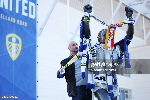 Fan wraps a scarf around a statue of Billy Bremner, former Scottish football player and manager, outside the stadium prior to the Sky Bet...