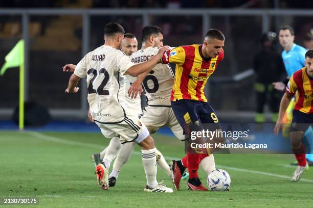 Nikola Krstovic of Lecce competes for the ball with Houssem Aouar and Leandro Paredes of Roma during the Serie A TIM match between US Lecce and AS...