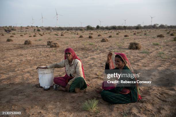 Indian villagers Mirga Devi, and Latchi Devi talk after finishing work harvesting and tending to a cumin crop on March 31, 2024 in Sodha village in...