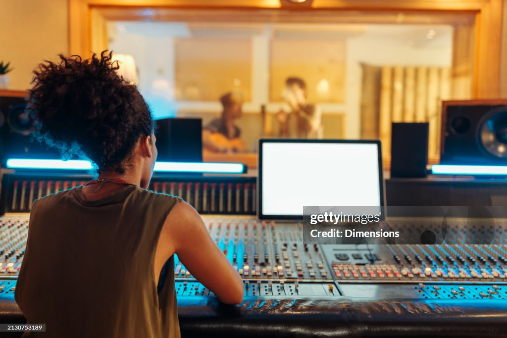 女性プロデューサーが曲のインストゥルメンタルをミキシングしている