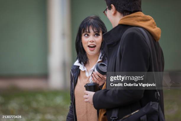 surprised female student talking to a colleague - shock stock pictures, royalty-free photos & images