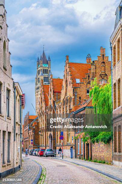 Brugge city historical centre, narrow cobblestone street with buildings and houses in Bruges old town Steenstraat quarter, St. Salvator's Cathedral church Romanesque style, Flemish Region, Belgium