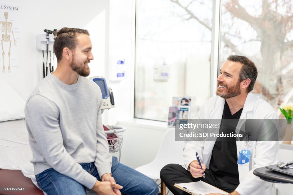 Male doctor and male patient smile at each other