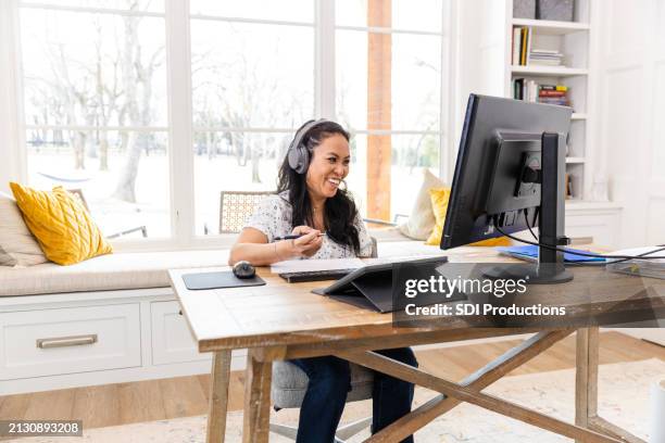female freelancer smiles during virtual meeting with client - side hustle stock pictures, royalty-free photos & images