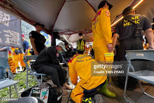 Member of a search and rescue team provides medical care to a man, who was evacuated from the Taroko area, in a makeshift clinic in Hualien on April...