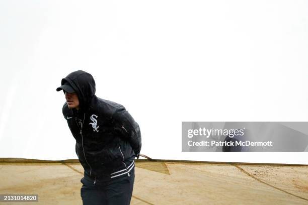 Member of the Chicago White Sox ground crew pulls the tarp onto the field during the top of the eighth inning against the Atlanta Braves at...