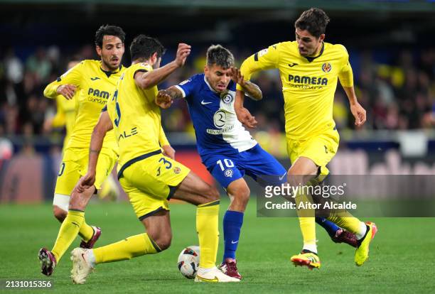 Angel Correa of Atletico Madrid is challenged by Raul Albiol and Santi Comesana of Villarreal CF during the LaLiga EA Sports match between Villarreal...