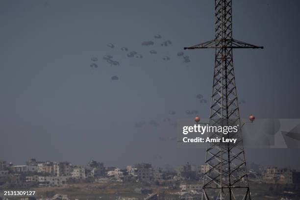 An airplane drops aid into the Gaza Strip as seen from a position on the Israeli side of the border on April 4, 2024 in Southern Israel, Israel....