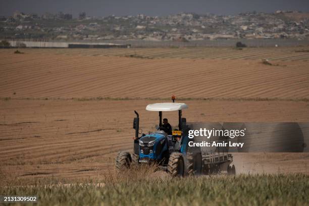 Farmer moves with a tractor as he is working near the border with the Gaza Strip on April 4, 2024 in Southern Israel, Israel. Israeli officials...