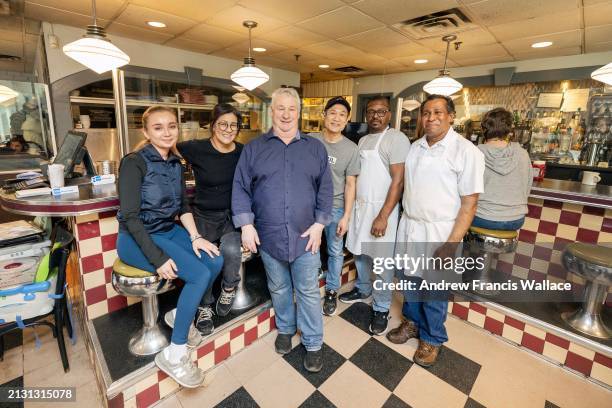 March 20 - Co-owners Pierre Hamel, centre with collar shirt, and Peter Lau, centre t-shirt and black cap, pose with staff, at Flo's Diner, a second...