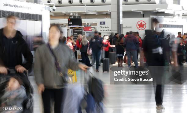 Terminal 1 travellers line up as travellers fill the airport on the some of the busiest days as they flock to March Break destinations at Pearson...
