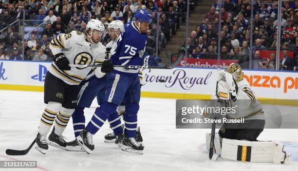 Toronto Maple Leafs right wing Ryan Reaves tries to tip the puck past Boston Bruins goaltender Jeremy Swayman as Boston Bruins defenseman Parker...