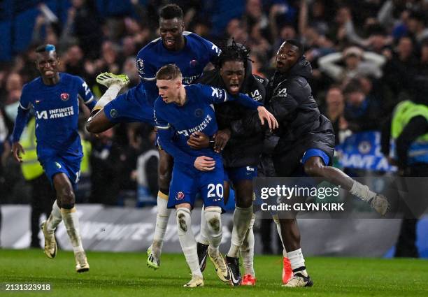 Chelsea's English midfielder Cole Palmer celebrates with teammates after scoring the fourth and winning goal of his team during the English Premier...
