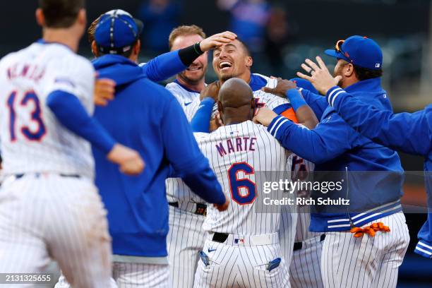 Tyrone Taylor of the New York Mets is jumped by Pete Alonso, Starling Marte and other teammates after hitting an RBI single in the ninth inning to...