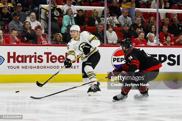 Brandon Carlo of the Boston Bruins shoots the puck past Jaccob Slavin of the Carolina Hurricanes during the first period at PNC Arena on April 04,...