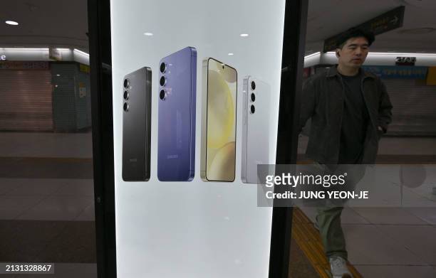 Man walks past an advertisement for the Samsung Galaxy S24 series smartphones at a subway station in Seoul on April 5, 2024. Samsung Electronics said...