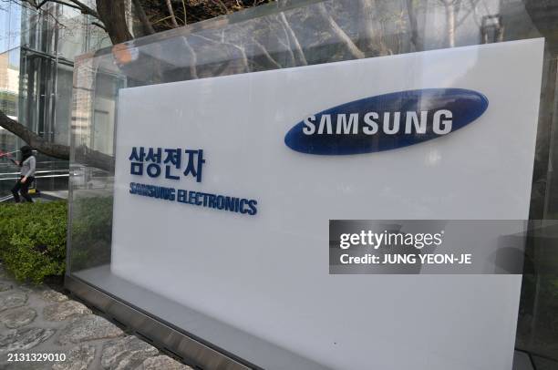 Woman walks past a signboard of Samsung Electronics displayed outside the company's Seocho building in Seoul on April 5, 2024. Samsung Electronics...