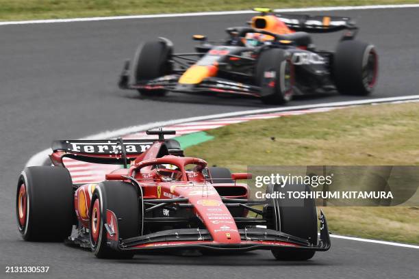 Ferrari's Monegasque driver Charles Leclerc and Red Bull Racing's Mexican driver Sergio Perez take a corner during the first practice session ahead...