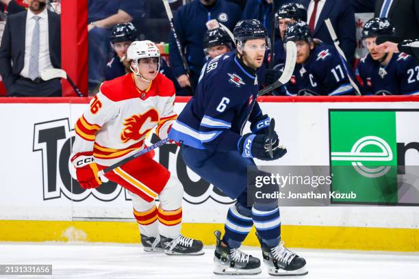 Martin Pospisil of the Calgary Flames and Colin Miller of the Winnipeg Jets keeps an eye on the play during first period action at the Canada Life...