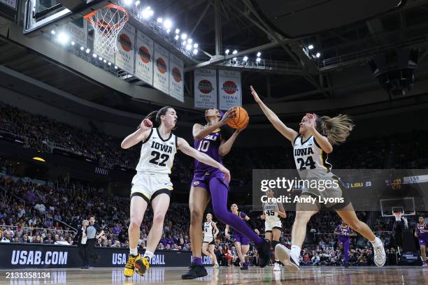 Angel Reese of the LSU Tigers shoots the ball over Caitlin Clark and Gabbie Marshall of the Iowa Hawkeyesduring the first half in the Elite 8 round...