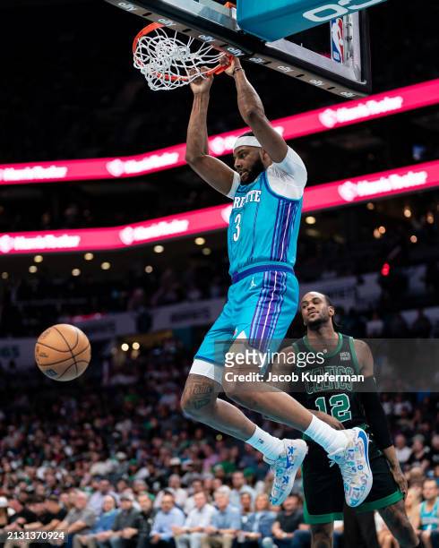 Marques Bolden of the Charlotte Hornets dunks the ball while guarded by Oshae Brissett of the Boston Celtics in the first quarter during their game...