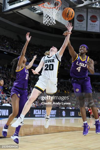 Kate Martin of the Iowa Hawkeyes shoots the ball over Flau'jae Johnson of the LSU Tigers during the second half in the Elite 8 round of the NCAA...