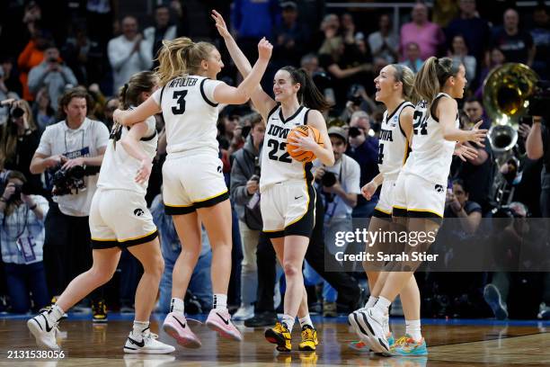 Caitlin Clark of the Iowa Hawkeyes and her teammates celebrate after beating the LSU Tigers 94-87 in the Elite 8 round of the NCAA Women's Basketball...