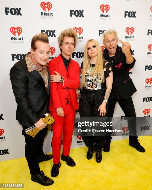 Tré Cool, Billie Joe Armstrong and Mike Dirnt of Green Day, winners of the Landmark Award, pose in the press room with Avril Lavigne during the 2024...