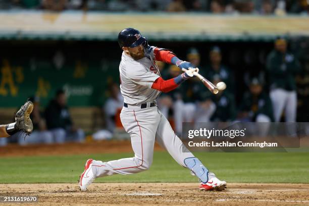 Trevor Story of the Boston Red Sox hits an RBI double in the top of the third inning against the Oakland Athletics at Oakland Coliseum on April 01,...