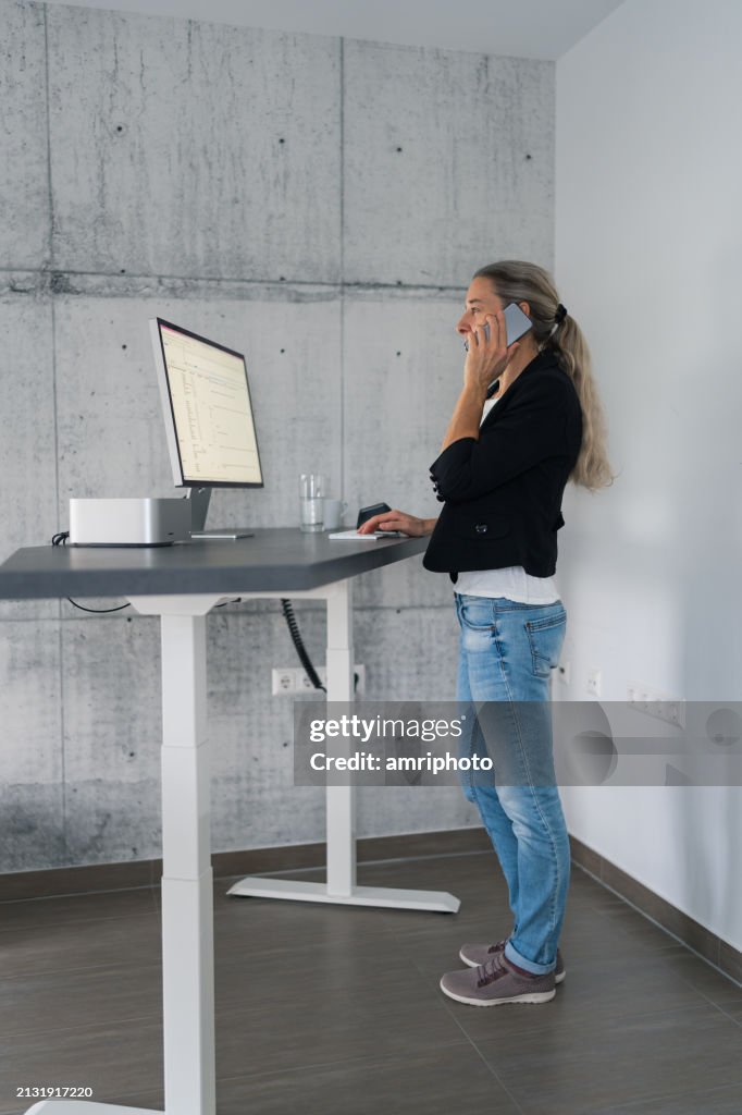 Woman working at adjustable stand desk in home office