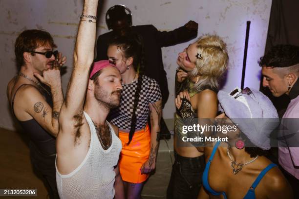 group of carefree non-binary friends dancing with each other at nightclub - andare in discoteca foto e immagini stock