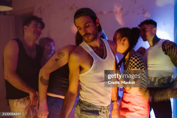 gay person dancing with non-binary friends at nightclub - homens-gays imagens e fotografias de stock