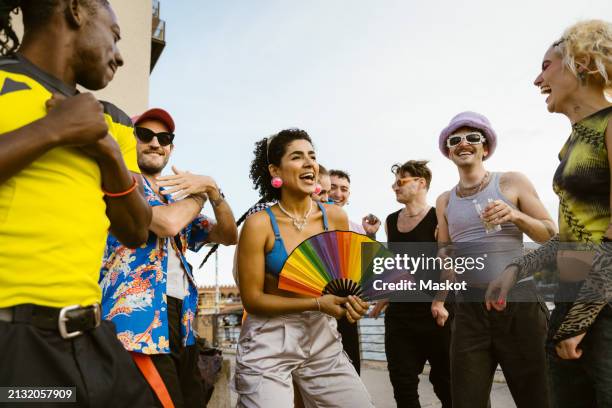 happy non-binary person having fun while dancing amidst friends in city - hand fan stock pictures, royalty-free photos & images