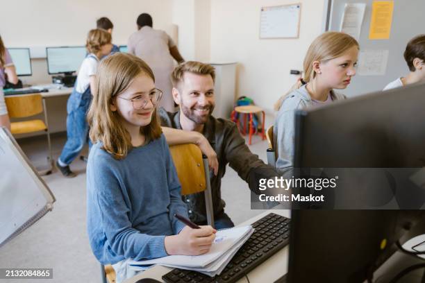 smiling male teacher with students learning at computer class in school - book icon stock pictures, royalty-free photos & images