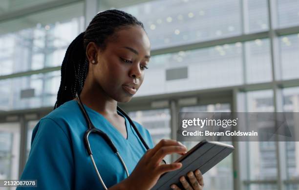 black woman, nurse and search with tablet in hospital for public service, committed and satisfied. female person, closeup and internet for healthcare research at work, wellness and medical career - public service stock pictures, royalty-free photos & images