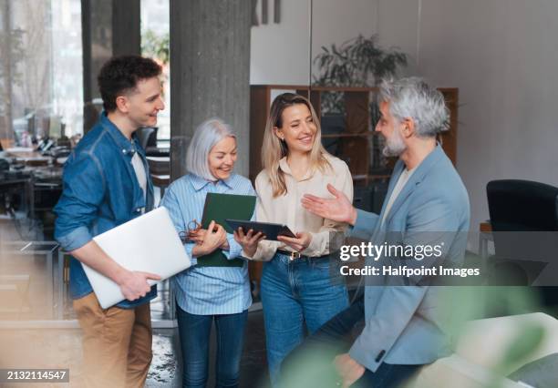 age diverse team in a business meeting. colleagues and manager in various age groups having casual discussion during meeting, workshop in office. inclusivity and diversity in terms of age - leeftijdsverschil stockfoto's en -beelden