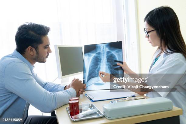 the doctor is explaining the chest x-ray film to the patient - mukoviszidose stock-fotos und bilder