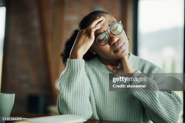 young black woman having a headache at home. - gewicht stockfoto's en -beelden