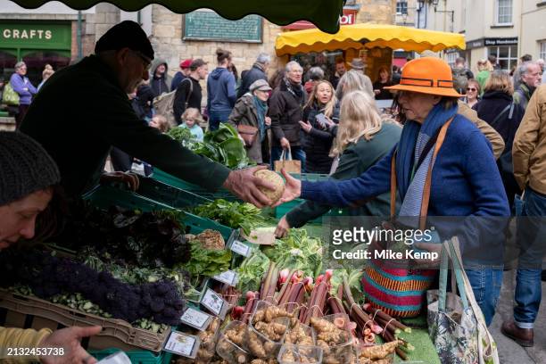 People buying vegatables from a fruit and veg stall at Stroud Farmers Market on 30th March 2024 in Stroud, United Kingdom. Stroud is a market town...