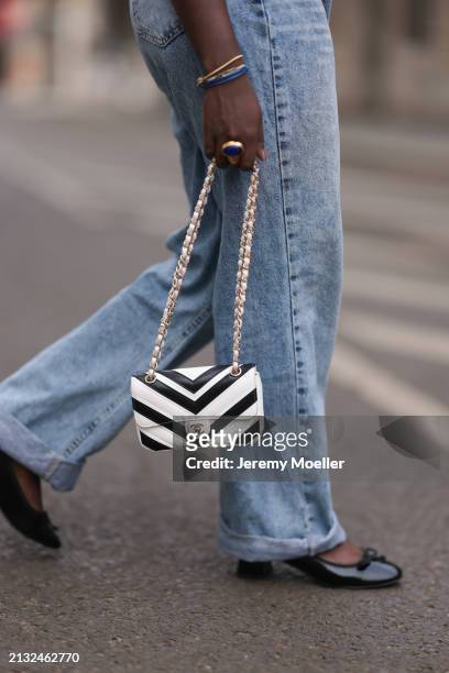 Lois Opoku seen wearing blue denim jeans pants, ASOS black shoes, Chanel white and black mini bag on April 01, 2024 in Berlin, Germany.