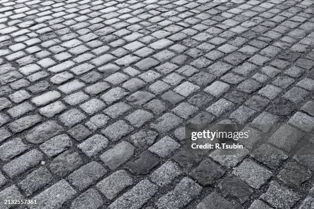 old wet stone paved avenue street road - asphalt paver stock pictures, royalty-free photos & images