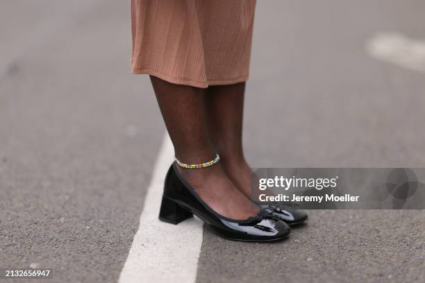 Lois Opoku seen wearing Chanel black bag, ASOS black patent heels, ASOS beige brown dress, ASOS golden earrings on April 01, 2024 in Berlin, Germany.