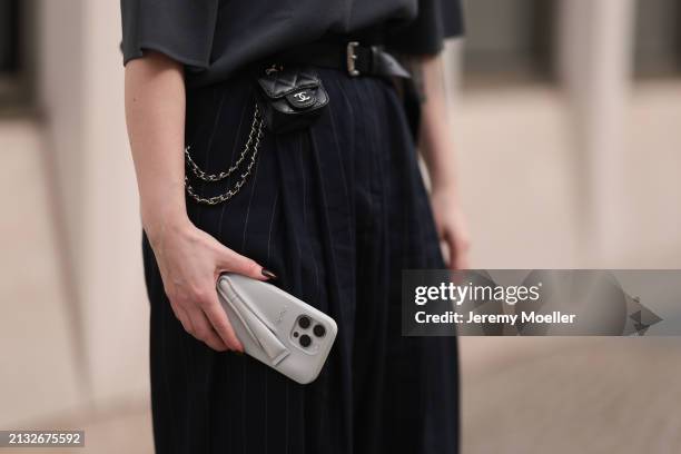 Maria Barteczko seen wearing The Frankie Shop grey shortsleeved cotton knit t-shirt, The Frankie Shop dark blue belted pinstriped oversized pants,...