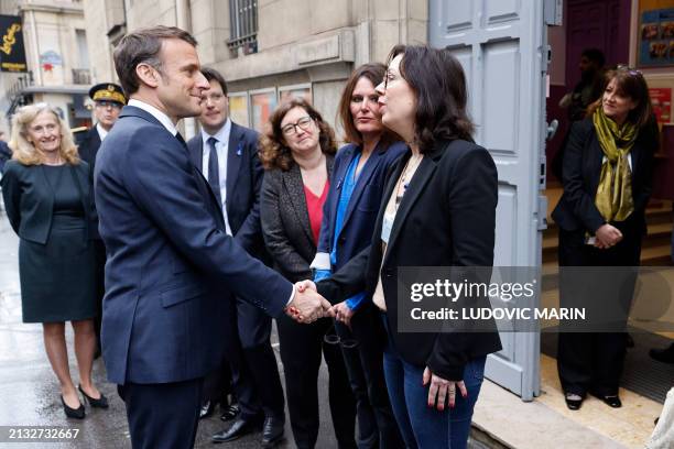 School teachers greet French President Emmanuel Macron and France's Minister for Education and Youth Nicole Belloubet upon their arrival to visit the...