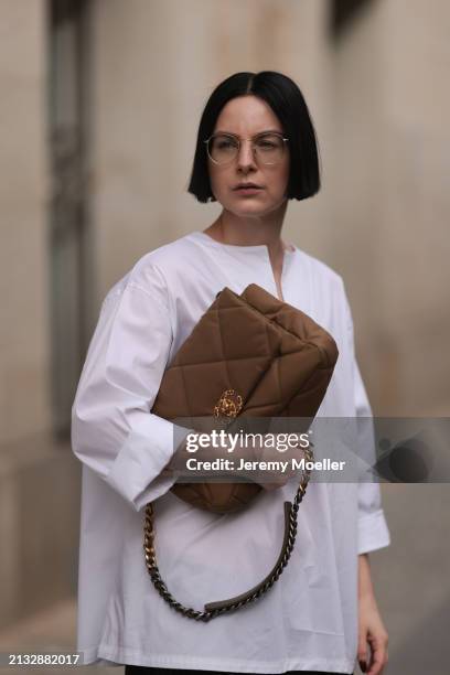 Maria Barteczko seen wearing Ray-Ban gold round retro glasses, WENDYKEI white cotton oversized shirt and Chanel 19 beige quilted canvas flap bag, on...